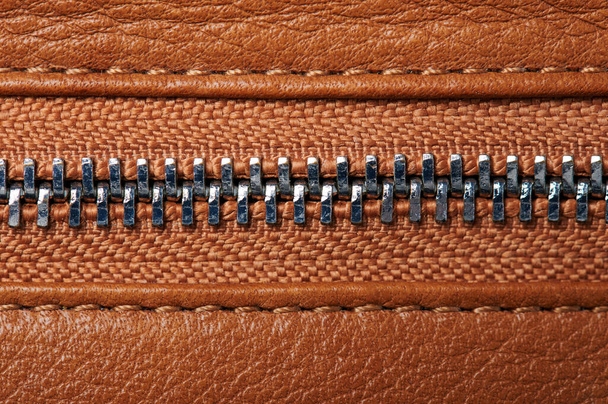 Metal zipper close up view on brown leather background - Photo, Image