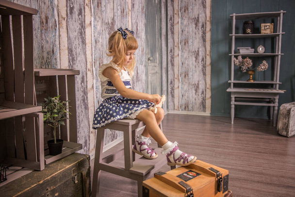 Portrait of a little girl in retro vintage photographic studios. - Fotó, kép