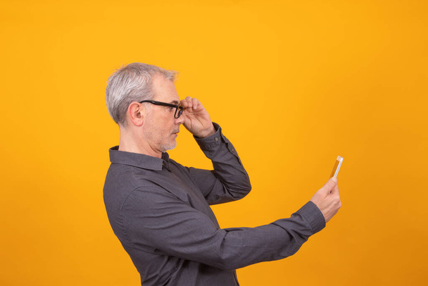 uomo adulto o anziano con telefono cellulare isolato su sfondo a colori - Foto, immagini
