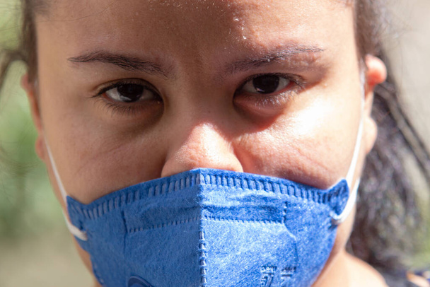 Nainen, jolla on jälkiä kasvoissa ja naamio pff2 n95, suojaa koronavirusta vastaan Rio de Janeirossa Brasiliassa
. - Valokuva, kuva