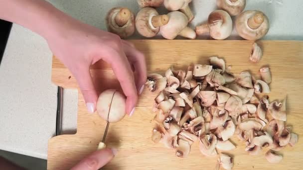 Champignon-Pilze auf einem Holzbrett in Scheiben schneiden. Selektiver Fokus aus der Nähe - Filmmaterial, Video