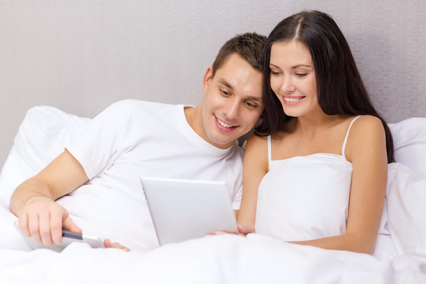 Smiling couple in bed with tablet pc computers - Foto, immagini