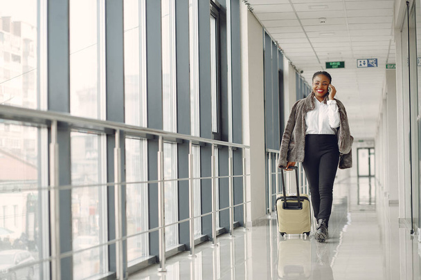 Black woman with suitcase at the airport - Photo, image