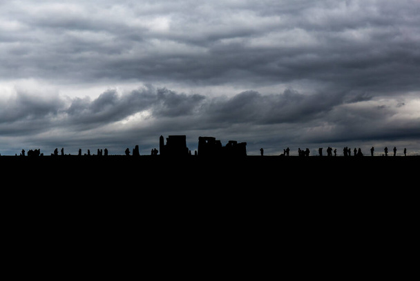 Stonehenge felhőkarcoló naplementekor, az ég felhős és vihar fenyeget. - Fotó, kép