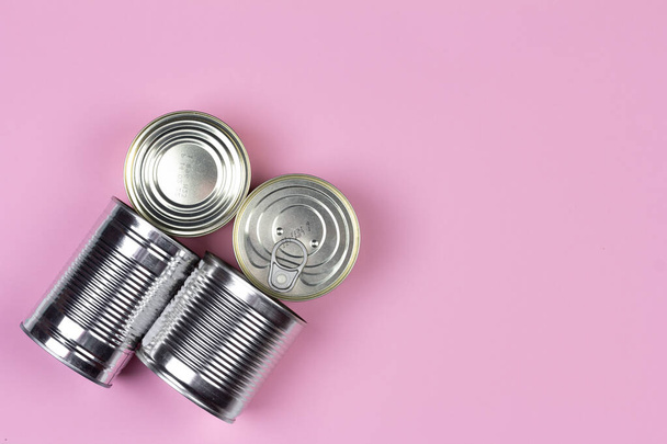 Canned food supplies crisis food stock for quarantine isolation period on pink background with copy space, top view. Food delivery, Donation, coronavirus quarantine. - Foto, Imagen
