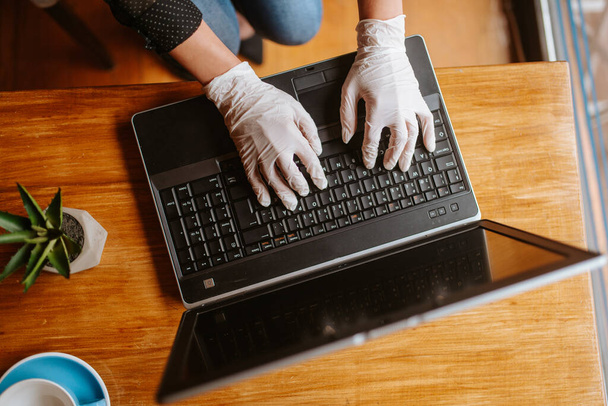 ノートパソコンのキーボードの手袋で女性の手を閉じる - 写真・画像