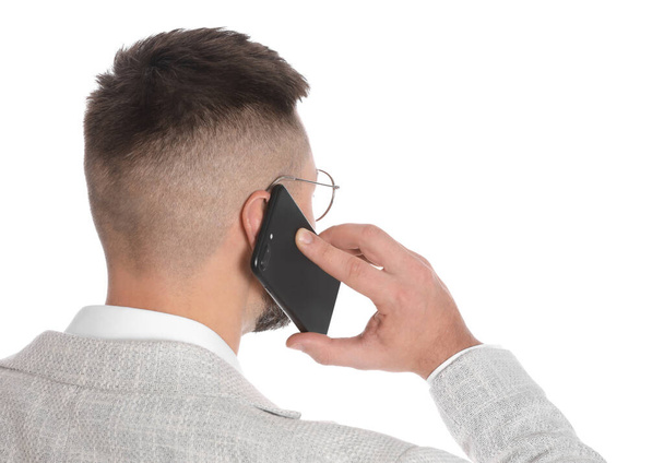 Businessman talking on mobile phone against white background - Foto, afbeelding