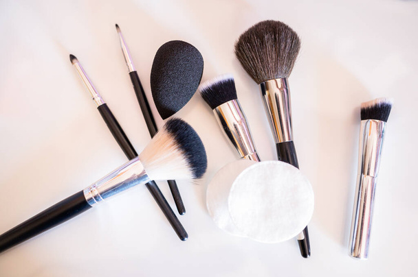 Diverse make-up borstels samen met een make-up verwijderen kwastje en make-up spon.Cosmetisch concept. - Foto, afbeelding