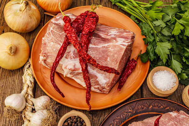Rozmanité syrové vepřové maso. Čerstvé hřbety, koření, voňavá zelenina a petržel. Vintage dřevěné desky stůl, zavřít - Fotografie, Obrázek
