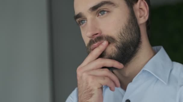 Handsome concentrated young business man indoors in office thinking - Záběry, video