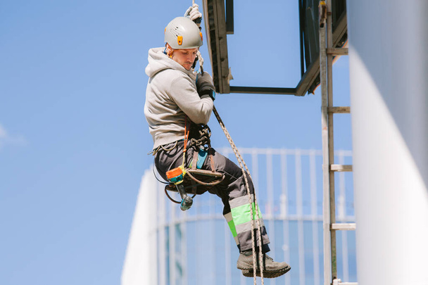 Industrial climber in helmet and overall working on height. Risky job. Professional worker - Photo, image
