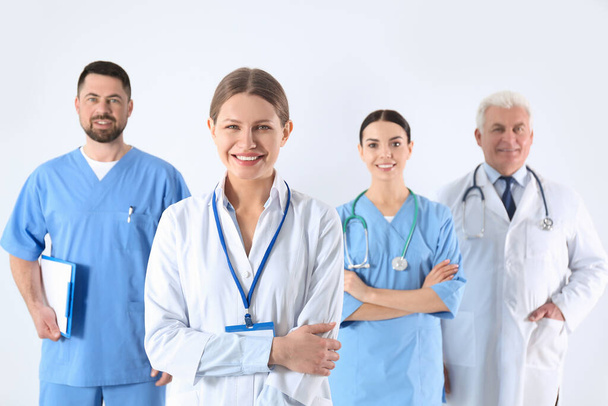 Group of doctors against light background. Medical service - Photo, image