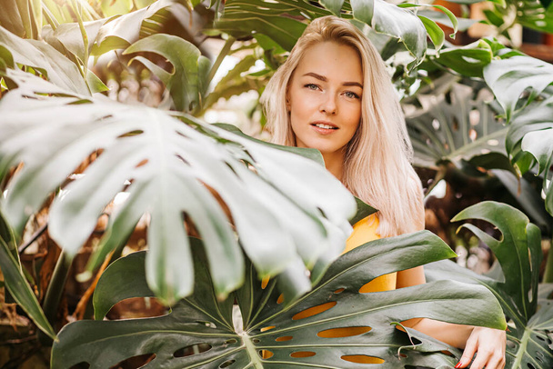 Woman in swimsuit on tropical plants background - Foto, afbeelding