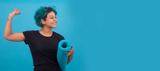girl or woman with gym mat and raised arm isolated on color background - Photo, Image
