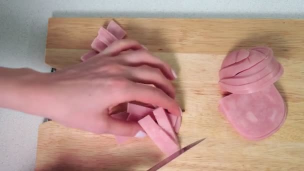 Woman cutting the ham on wooden board in kitchen. - Footage, Video