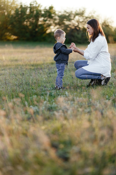 Mom playing with her little son in nature. Mother and son portrait - Foto, afbeelding