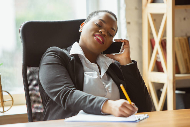 Donna d'affari afro-americana in abito da ufficio sorridente, sembra fiduciosa e felice, di successo
 - Foto, immagini