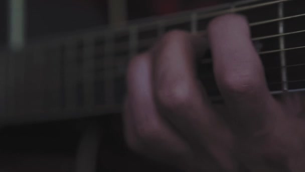 muziek, creativiteit, concert, zelf-isolatie concept. Close-up handen van de jongeman die een akoestische gitaar dreadnought speelt in zachte focus. Vingers sorteren snaren door akkoorden te drukken op frets van fretboard. - Video