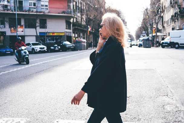 Adult lady talking on the phone and cross the street - Fotoğraf, Görsel