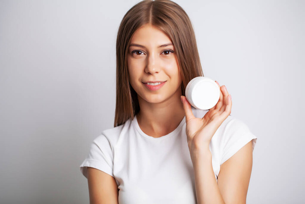 Woman Face Skin Cosmetics, pretty woman hold in hand facial cream - Fotografie, Obrázek