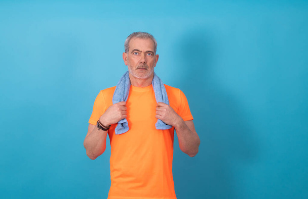 Porträt eines erwachsenen Mannes mit Sportbekleidung isoliert auf farbigem Hintergrund - Foto, Bild