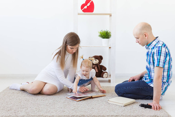 Familia feliz, madre, padre y su bebé juntos jugando en la sala de estar en casa. Concepto de niños y niños pequeños
. - Foto, imagen