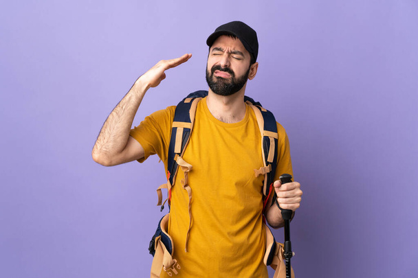 Caucasian handsome man with backpack and trekking poles over isolated background with tired and sick expression - Photo, Image