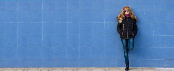vrouw op straat buiten leunend op de muur - Foto, afbeelding