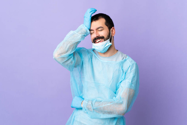 Chirurg man met baard met blauw uniform over geïsoleerde paarse achtergrond heeft iets gerealiseerd en van plan de oplossing - Foto, afbeelding