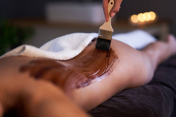 Relaxed woman receiving a chocolate back massage - Zdjęcie, obraz