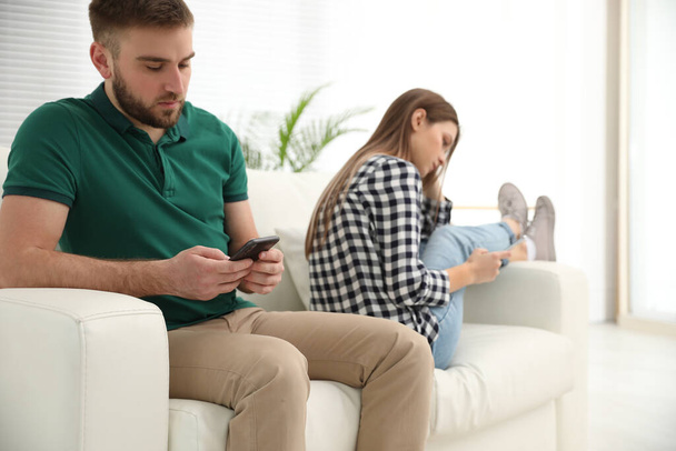 Casal viciado em smartphones em casa. Problemas de relacionamento
 - Foto, Imagem