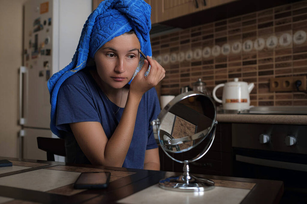 Kobieta stosująca make up produkt urody z okrągłym lustrem makijażu w domu kuchnia rano rutynowych. piękne Azji lady otrzymywać gotowy stosując makijaż oko z pędzlem. - Zdjęcie, obraz