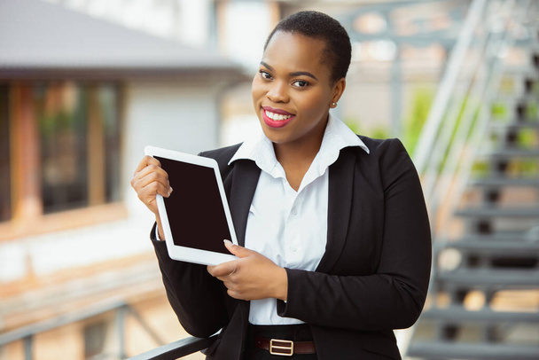 African-american businesswoman in office attire smiling, looks confident and happy, successful - Φωτογραφία, εικόνα