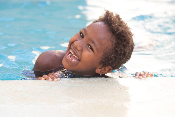 Pequena criança africana curtindo o verão na piscina
  - Foto, Imagem
