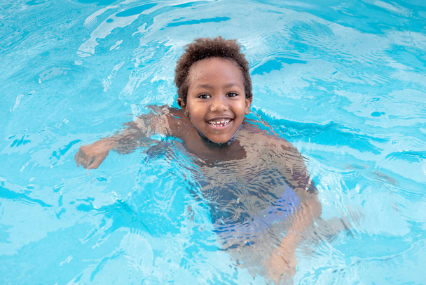 Μικρό αφρικανό παιδί που απολαμβάνει το καλοκαίρι στην πισίνα  - Φωτογραφία, εικόνα