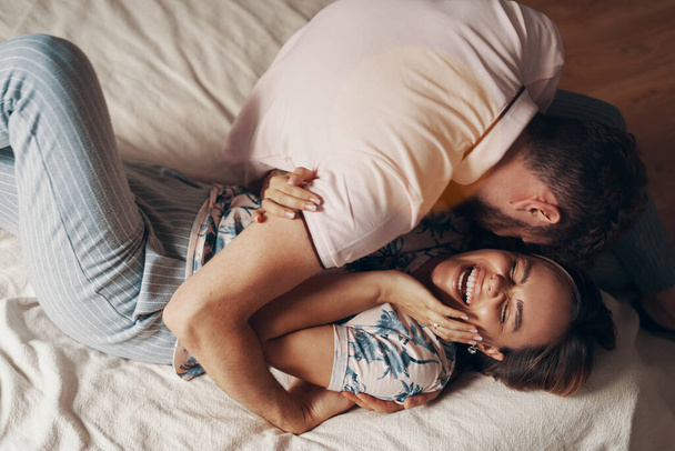 Влюблённая пара обнимается на кровати
 - Фото, изображение