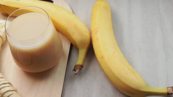 Banana smoothie. Bananas on a gray light background, selective focus - Footage, Video