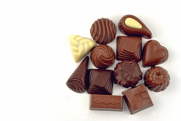 Doces de chocolate sortidas no fundo branco
 - Foto, Imagem