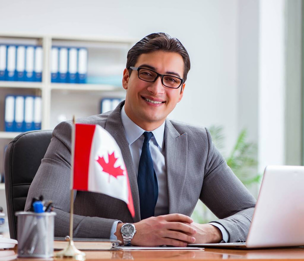 Επιχειρηματίας με καναδική σημαία στο γραφείο - Φωτογραφία, εικόνα