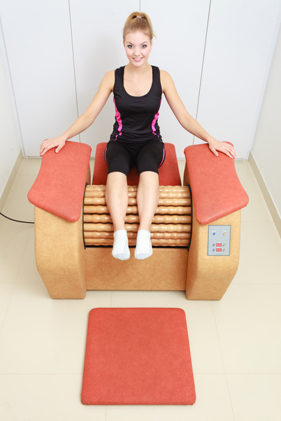 Girl in sportwear on relax massage equipment healthy spa salon - Photo, image