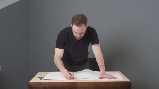 Man cuts paper on white - Video, Çekim