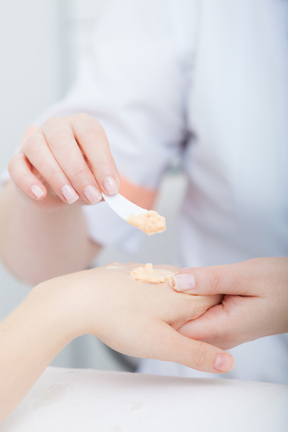 Beautician applying moisturizing cream on client hands. Beauty salon - Фото, зображення
