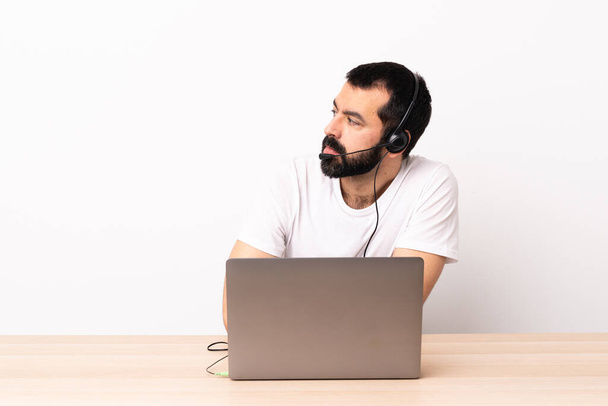 Telemarketer caucasian man working with a headset and with laptop keeping the arms crossed. - Foto, immagini