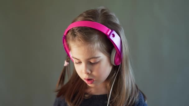 two adorable girls with headphones listen to music and dance - Video