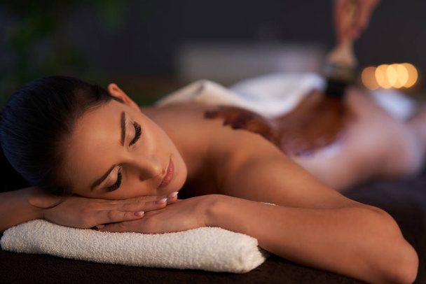 Mulher relaxada recebendo uma massagem nas costas de chocolate
 - Foto, Imagem