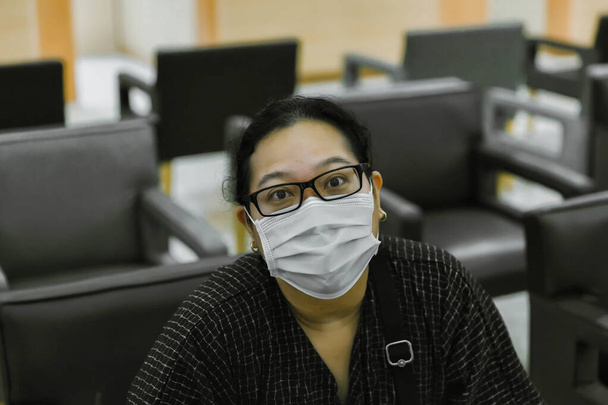 Asian woman in a mask for COVID-19 or corona virus, for protection against the crown virus. Asian woman with protective mask because dirty air smog, PM2.5. Coronavirus woman walking with surgical mask - Foto, afbeelding