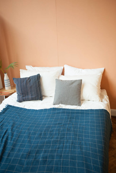 Het interieur van het appartement met een blauwe deken op het bed - Foto, afbeelding