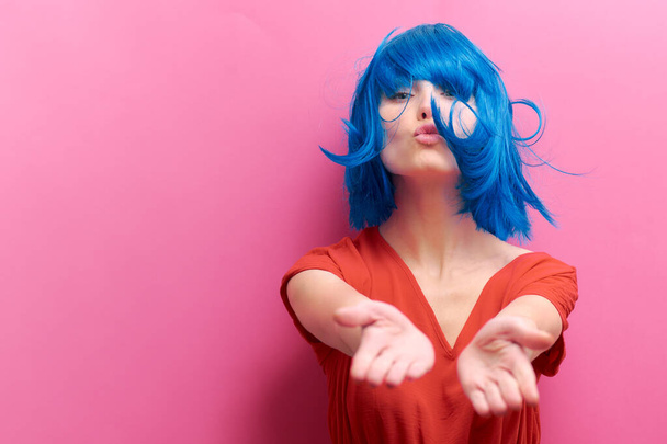 studio portrait of a sexy beautiful girl with a smile in motion on a pink background. Girl with blue hair - Φωτογραφία, εικόνα
