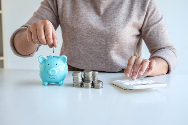 Young woman putting coins into piggy bank planning growing saving to strategy with money box for future plan fund of travel, education, home and retirement. - Foto, Bild