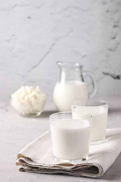 Кефір або Айран ферментований напій в двох склянках, молоко в глечику і сир в мисці на світло-сірому фоні, Крупним планом, вертикальний формат
 - Фото, зображення